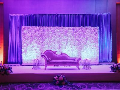 Decorated photozone for wedding with sofa, flowers an boquets in violet colours